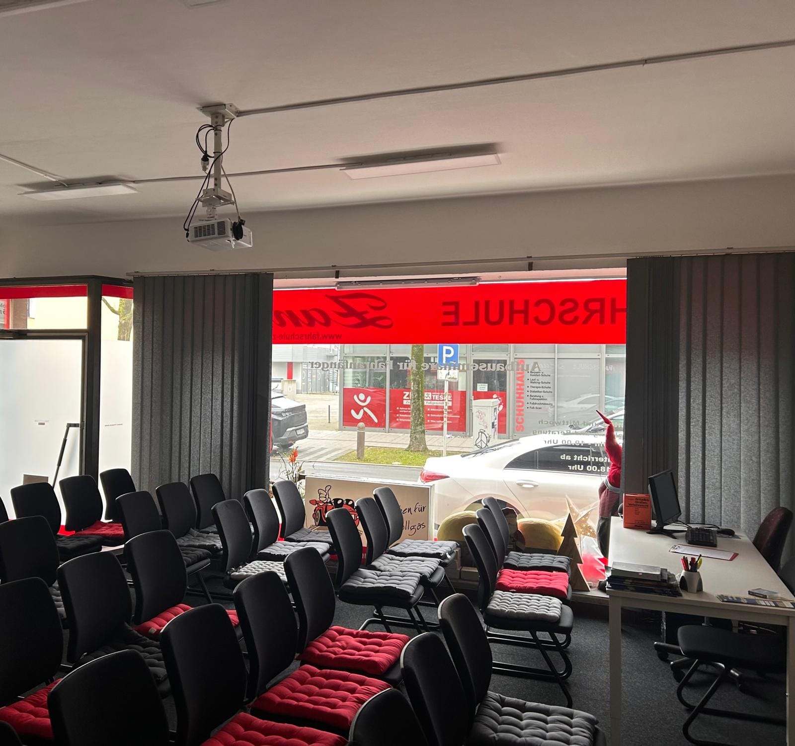 Blick aus dem Büro der Fahrschule Zanke auf die Straße, mit roter Fahrschule-Zanke-Beschriftung im Schaufenster.