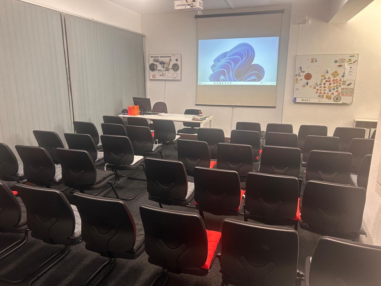 Theorieraum der Fahrschule Zanke mit Beamer-Leinwand und einer Magnettafel voller Verkehrszeichen.